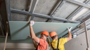 Two man installing ceiling materials