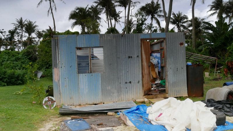 A small makeshift structure made of corrugated metal sheets, partially damaged.